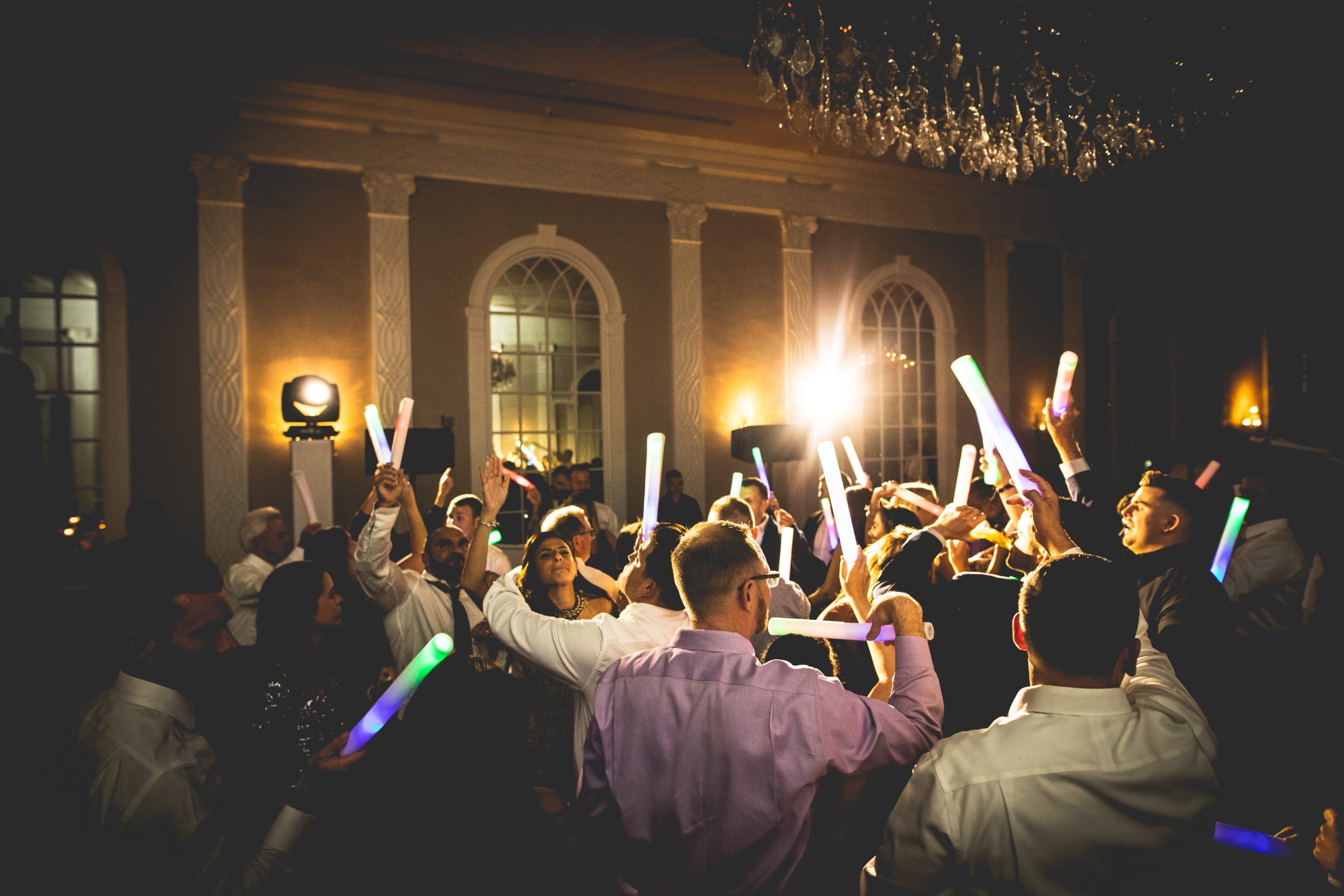 A packed dance floor lit up with glowing lights at a celebration