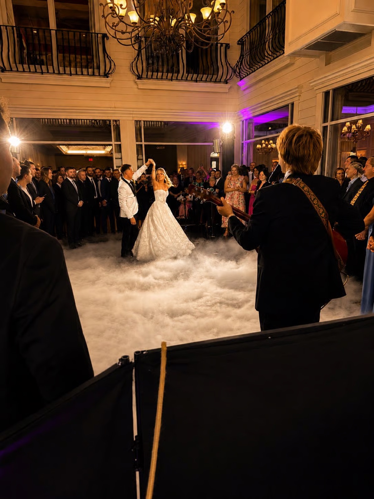 A couple's first dance on a cloud of dry ice with a live guitarist