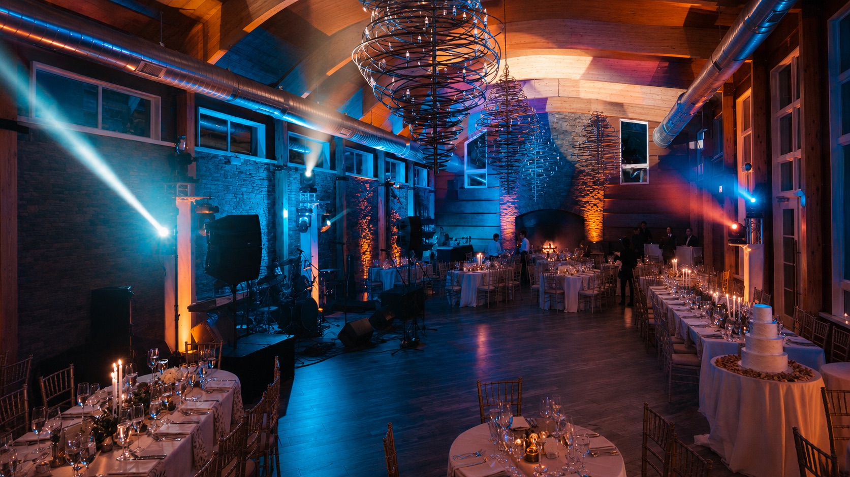 A performer on a cloud of dry ice under a monogram projection and colored lights