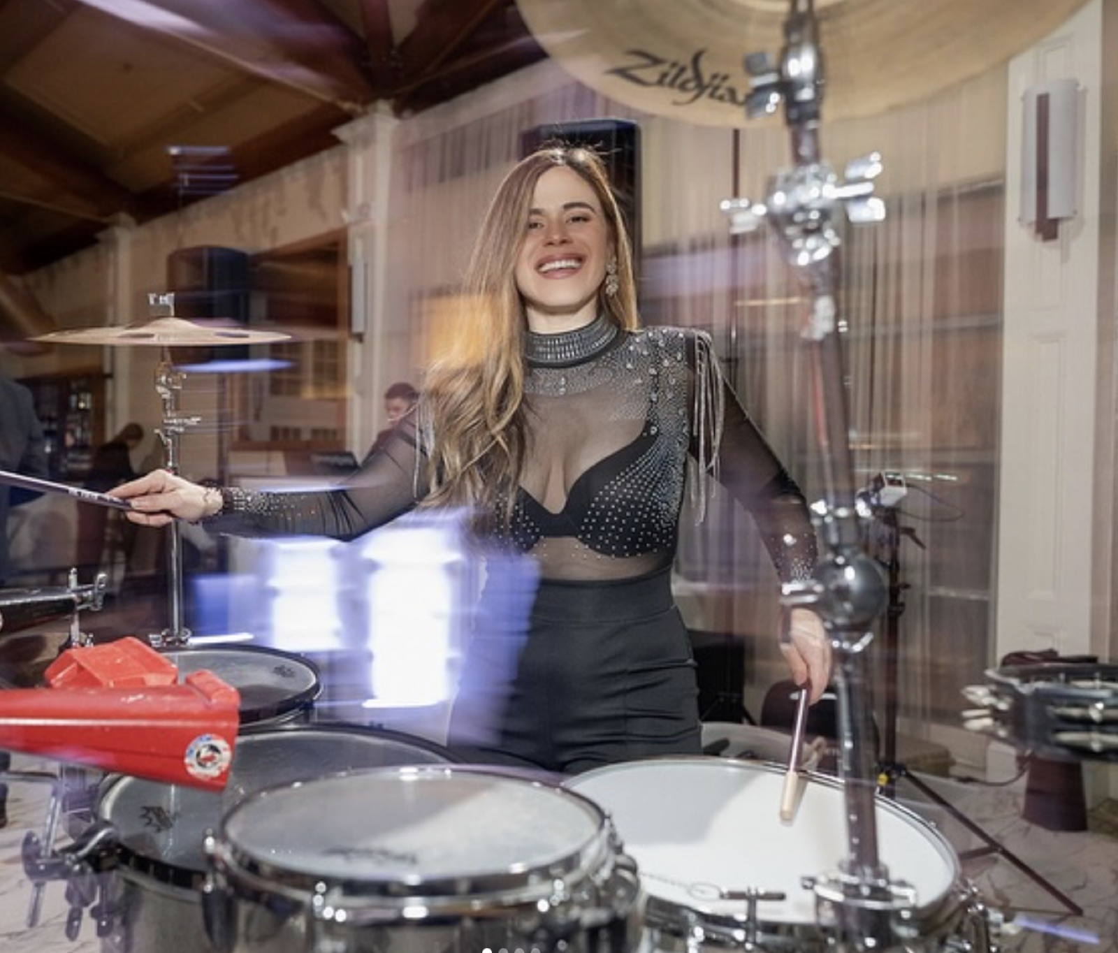 A live percussionist playing drums alongside the DJ